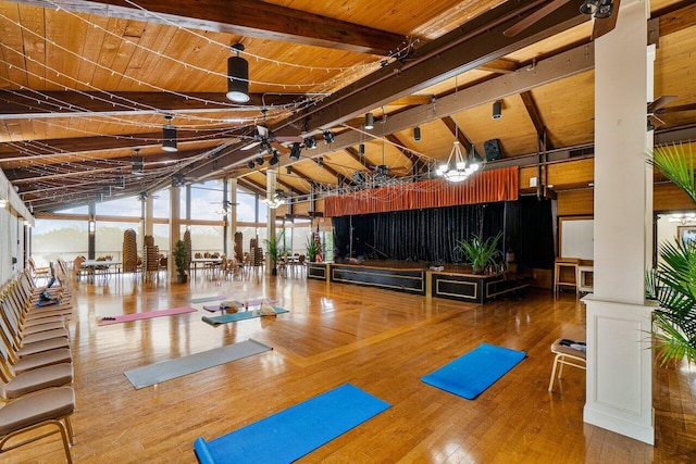 exercise room with hardwood / wood-style flooring, a wall of windows, wood ceiling, and high vaulted ceiling