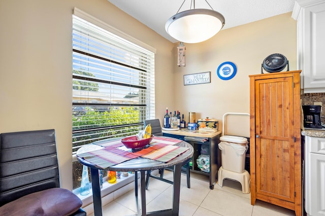 dining room with a textured ceiling and light tile patterned flooring