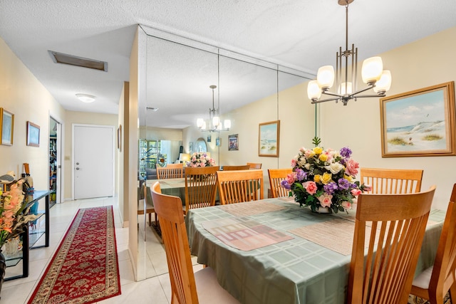 dining space with light tile patterned floors, a chandelier, and a textured ceiling