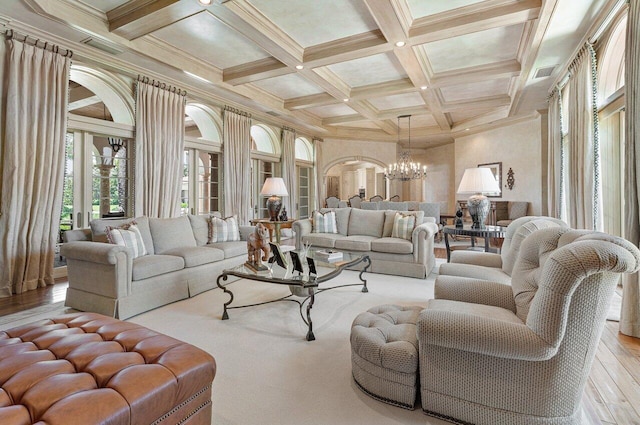 living room with hardwood / wood-style flooring, visible vents, a notable chandelier, and beamed ceiling