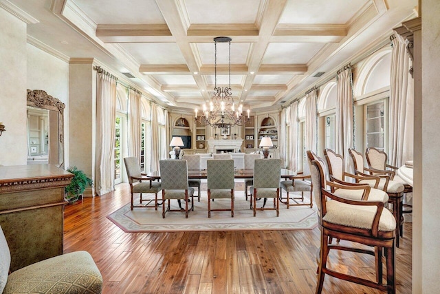 dining room featuring beamed ceiling, built in features, coffered ceiling, hardwood / wood-style flooring, and a chandelier