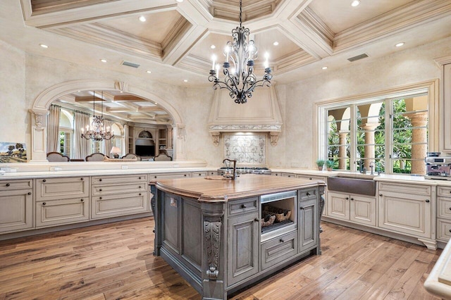 kitchen with a kitchen island with sink, a sink, visible vents, light wood-type flooring, and gray cabinets