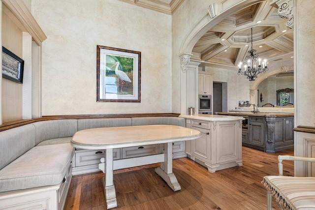 bathroom featuring beam ceiling, coffered ceiling, crown molding, and wood finished floors