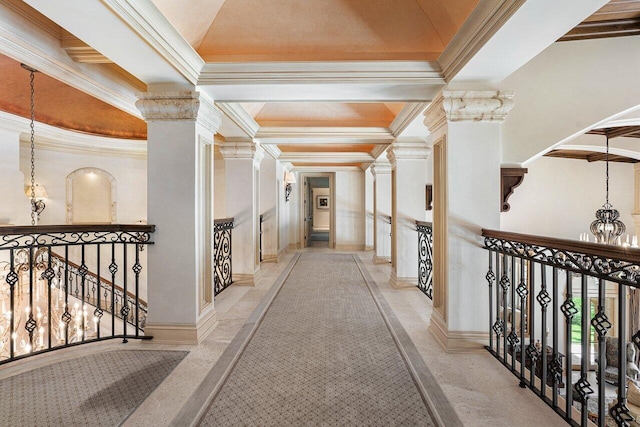 hallway with a chandelier, an upstairs landing, decorative columns, and crown molding