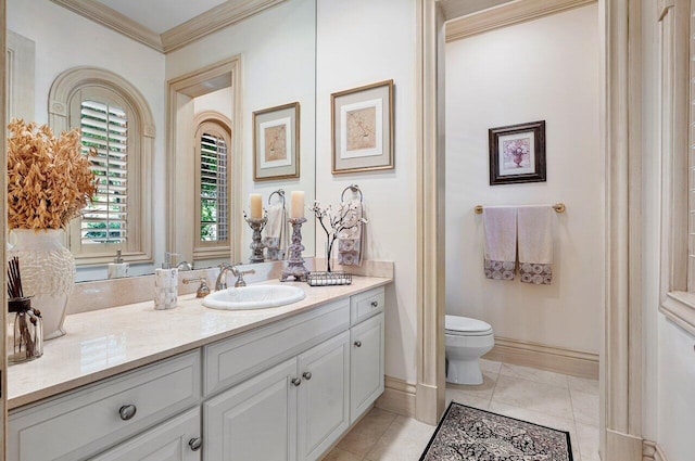 bathroom with tile patterned flooring, toilet, vanity, baseboards, and ornamental molding