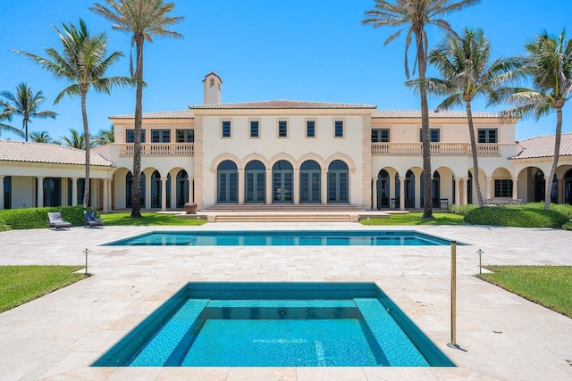 pool with a patio and an in ground hot tub