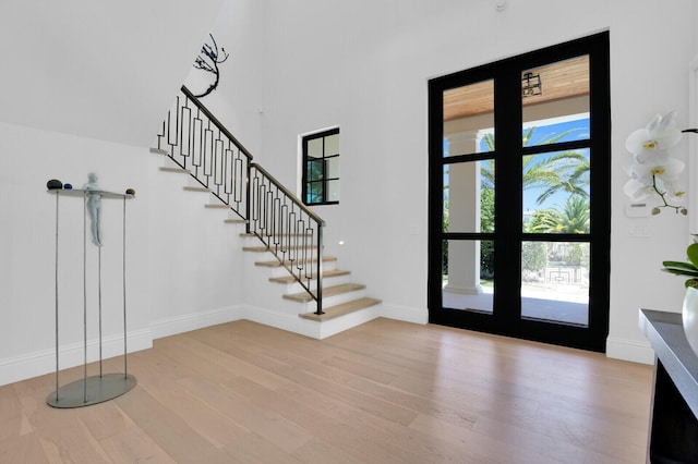 entrance foyer with light hardwood / wood-style floors and french doors