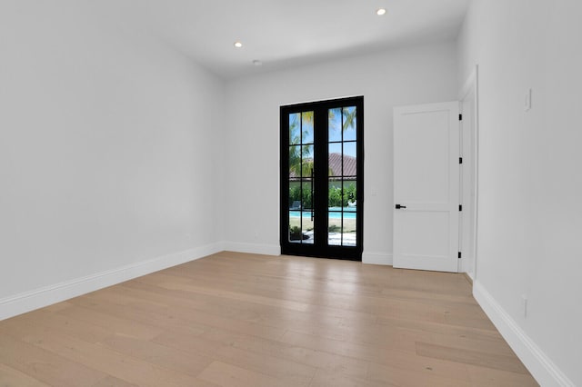 unfurnished room featuring light hardwood / wood-style floors and french doors