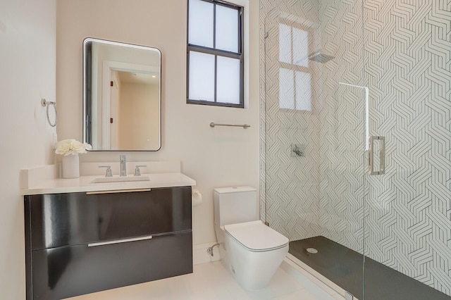 bathroom with a tile shower, toilet, and vanity