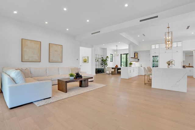 living room featuring light hardwood / wood-style flooring and an inviting chandelier