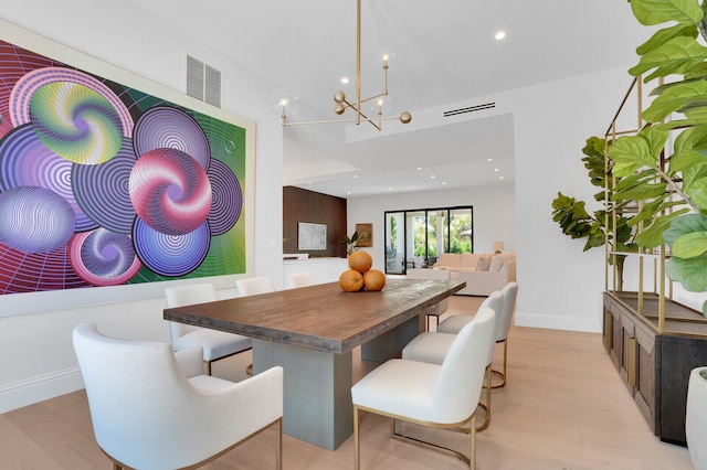 dining room with a notable chandelier and light wood-type flooring