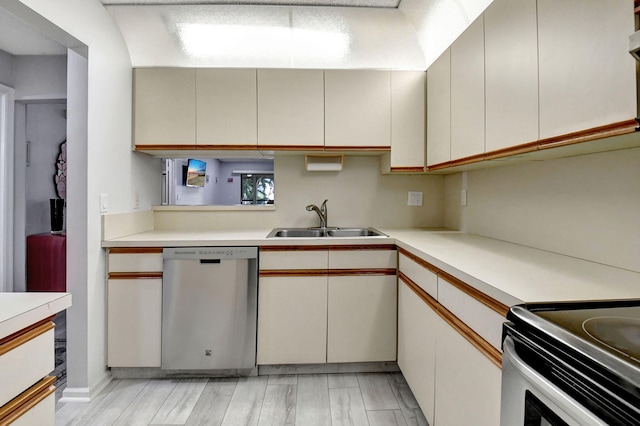 kitchen featuring sink, stainless steel dishwasher, and light hardwood / wood-style floors