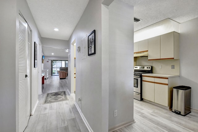 corridor featuring light hardwood / wood-style floors and a textured ceiling