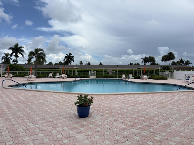 pool with a patio and fence