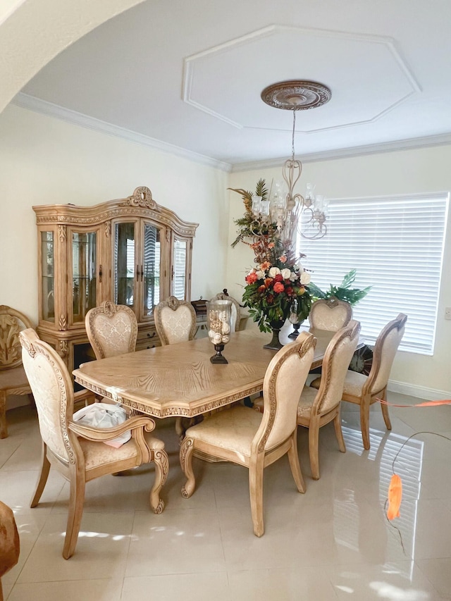 tiled dining room featuring a chandelier and crown molding