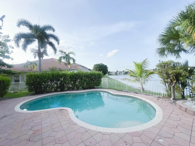 view of swimming pool with a patio area and a water view