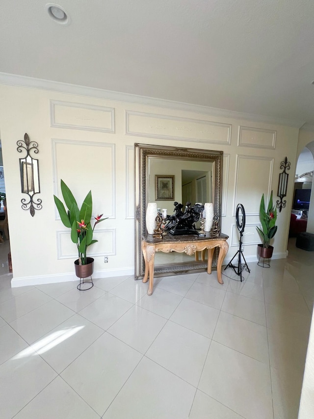 hallway featuring light tile patterned floors and ornamental molding