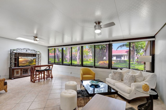 tiled living room with plenty of natural light and ceiling fan