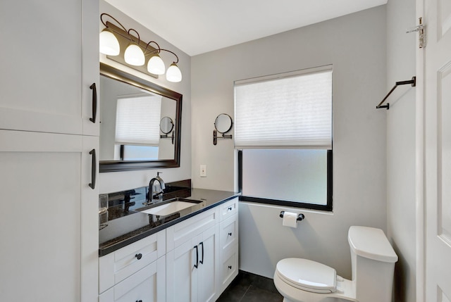 bathroom featuring tile patterned flooring, plenty of natural light, toilet, and vanity