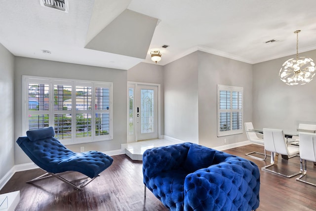 interior space featuring crown molding, an inviting chandelier, and hardwood / wood-style flooring