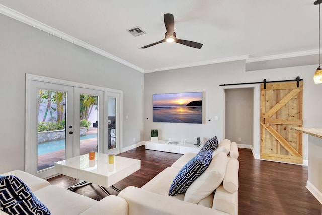 living room featuring french doors, ornamental molding, ceiling fan, a barn door, and dark hardwood / wood-style floors