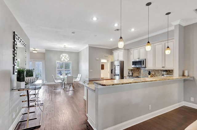 kitchen featuring kitchen peninsula, decorative light fixtures, stainless steel appliances, and dark wood-type flooring