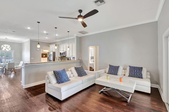 living room featuring ceiling fan with notable chandelier, dark hardwood / wood-style floors, and ornamental molding