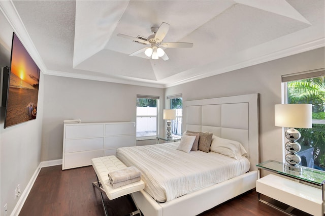 bedroom featuring dark hardwood / wood-style flooring, a raised ceiling, ceiling fan, and crown molding