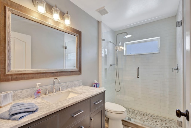 bathroom featuring toilet, vanity, and walk in shower