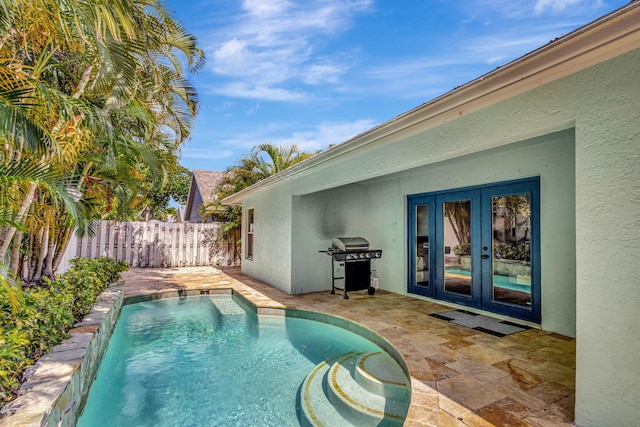 view of pool with french doors, a patio, and a grill