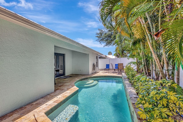 view of swimming pool featuring a patio area and french doors