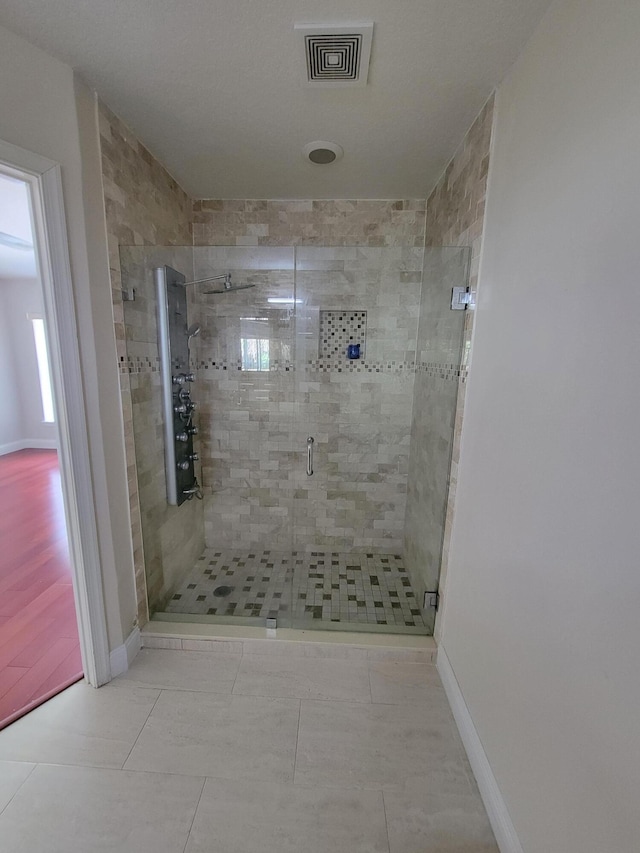 bathroom featuring tile patterned flooring and a shower with shower door