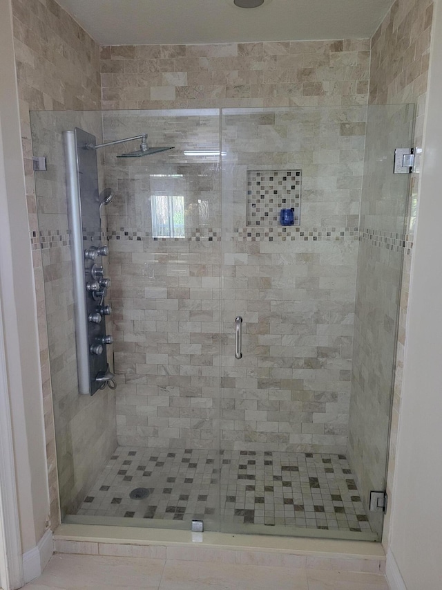 bathroom featuring tile patterned flooring and a shower with shower door