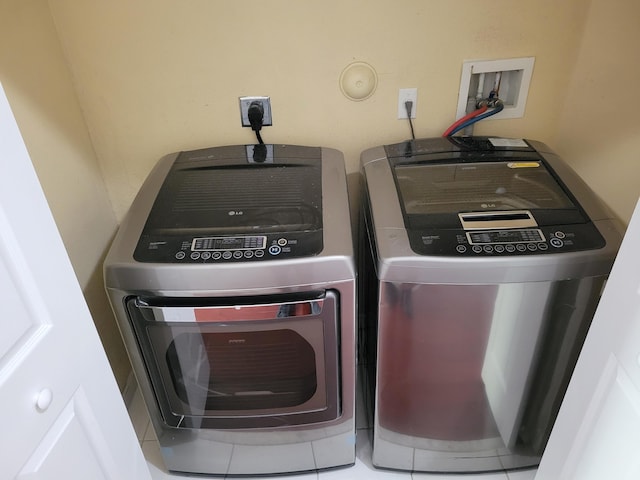 washroom featuring washing machine and dryer and tile patterned floors