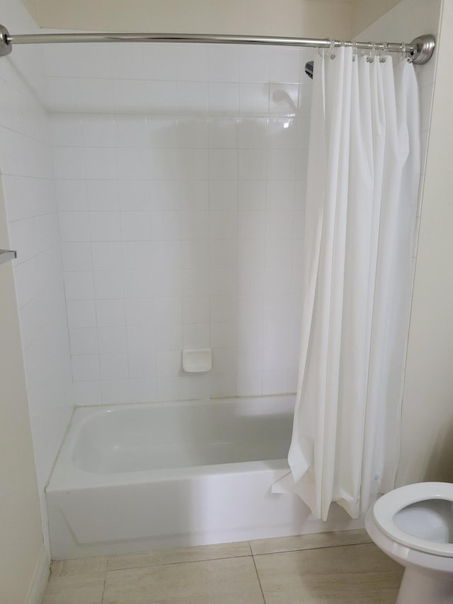 bathroom with tile patterned flooring, shower / bathtub combination with curtain, and toilet