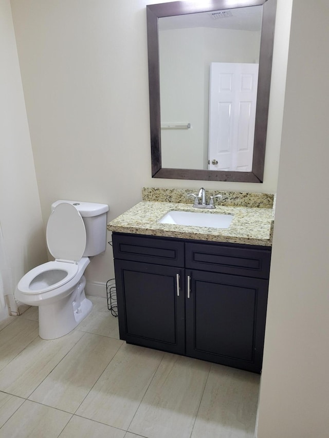 bathroom featuring tile patterned flooring, vanity, and toilet