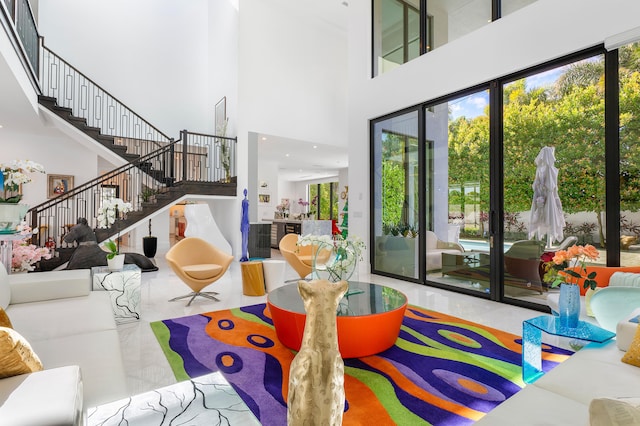 living room with a towering ceiling and tile floors