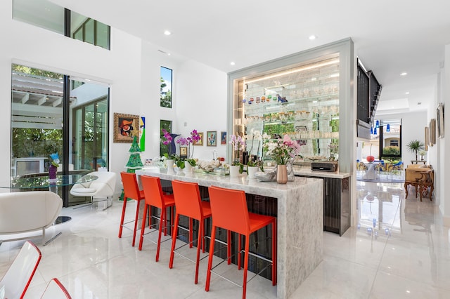 bar with light stone counters and light tile flooring