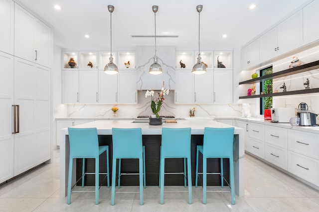 kitchen with a kitchen breakfast bar, white cabinets, a center island, and tasteful backsplash