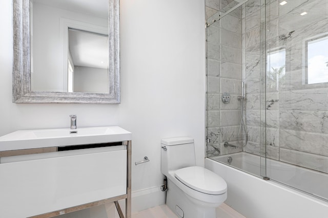 full bathroom featuring tiled shower / bath combo, vanity, and toilet