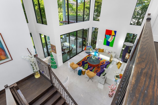 living room featuring tile flooring and a towering ceiling