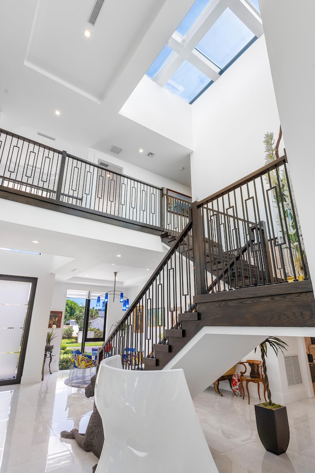 stairs featuring tile floors and a high ceiling