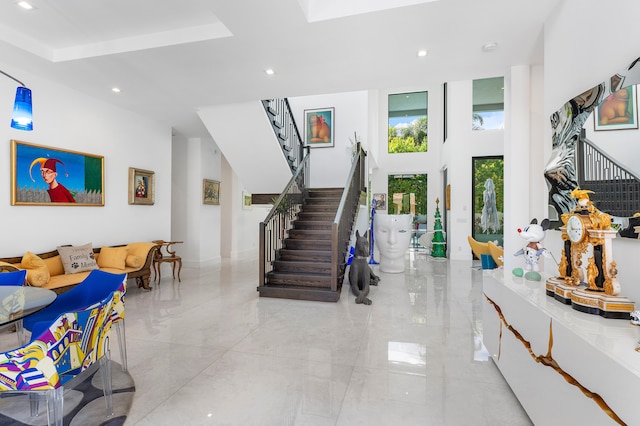 interior space featuring a towering ceiling and a tray ceiling