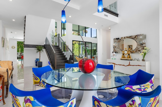 tiled dining room featuring a towering ceiling