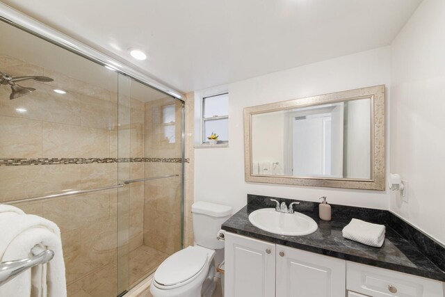 bathroom with a shower with shower door, toilet, and large vanity