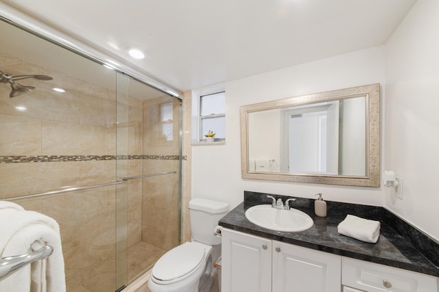 bathroom featuring vanity, a shower with shower door, and toilet