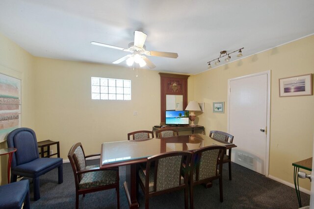 dining space with rail lighting, ceiling fan, and carpet