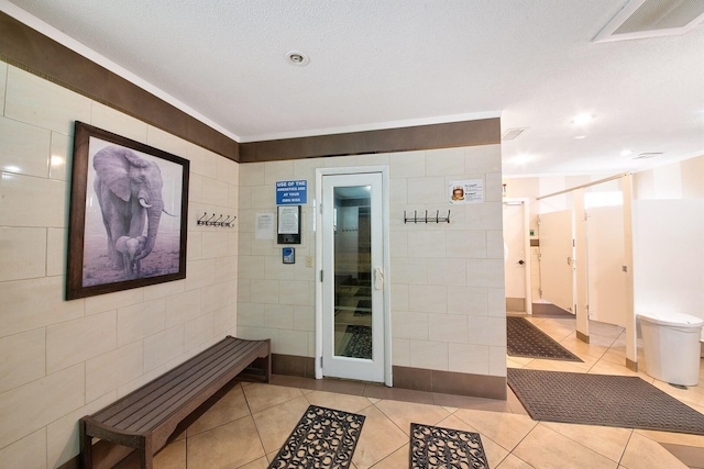 interior space with tile walls and light tile patterned flooring