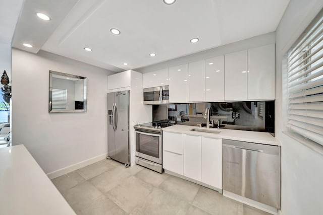 kitchen with appliances with stainless steel finishes, white cabinetry, and sink