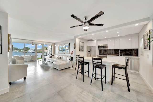 dining area featuring ceiling fan, sink, and a water view